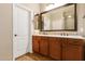 Bathroom featuring double sinks, wooden cabinets, a large mirror, and tile accents at 291 E Canyon Rock Rd, San Tan Valley, AZ 85143