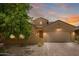 Beautiful single-story home with neutral-toned stucco and brick driveway at sunset at 291 E Canyon Rock Rd, San Tan Valley, AZ 85143