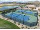 Aerial view of fenced tennis courts, lake and mountain views in the distance at 291 E Canyon Rock Rd, San Tan Valley, AZ 85143