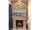 A stone fireplace is topped with a framed picture and adorned with a small lantern and vase at 29619 N 142Nd Pl, Scottsdale, AZ 85262