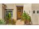 Close up of entry way with beautiful desert plants and custom wood door at 29619 N 142Nd Pl, Scottsdale, AZ 85262
