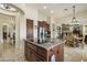 Open concept kitchen with wood cabinets, granite countertops, island cooktop, and view to living spaces at 29619 N 142Nd Pl, Scottsdale, AZ 85262