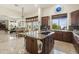 Spacious kitchen featuring wood cabinets, granite countertops, island cooktop, and large view windows at 29619 N 142Nd Pl, Scottsdale, AZ 85262