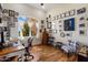 A home office with wood floors, large window, and walls decorated with pictures at 29619 N 142Nd Pl, Scottsdale, AZ 85262