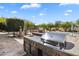 Outdoor kitchen with stainless steel grill, sink, and granite countertops, ideal for outdoor cooking and entertaining at 29619 N 142Nd Pl, Scottsdale, AZ 85262