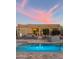 Backyard pool reflects the soft glow of the evening sky and the architecture of the home at 29619 N 142Nd Pl, Scottsdale, AZ 85262
