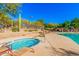 Inviting community spa and pool area featuring clear blue water, lounge chairs, and scenic desert landscaping with mature trees at 3038 W Trapanotto Rd, Phoenix, AZ 85086