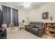 Cozy living room featuring tiled floors and a comfortable gray reclining couch at 3038 W Trapanotto Rd, Phoenix, AZ 85086