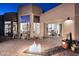 Inviting home exterior with desert landscaping, a fire pit, and large windows offering a peek into the interior at 30600 N Pima Rd # 81, Scottsdale, AZ 85266