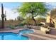 Sparkling pool with surrounding brick patio, native desert plants, and mature shade tree at 30600 N Pima Rd # 81, Scottsdale, AZ 85266