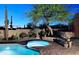 Inviting backyard pool and spa with lush desert landscaping and brick patio at twilight at 30600 N Pima Rd # 81, Scottsdale, AZ 85266
