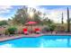Outdoor pool seating area with shade umbrella, lush landscaping, and desert views at 30600 N Pima Rd # 81, Scottsdale, AZ 85266