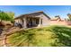 Private backyard featuring a covered patio area, grassy lawn, and easy to maintain desert landscaping at 3241 E Hampton Ln, Gilbert, AZ 85295