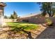 Beautiful backyard featuring lush green grass, mature trees, and a decorative gravel border at 3241 E Hampton Ln, Gilbert, AZ 85295