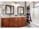 Bathroom featuring a double sink vanity with granite countertop, dark wood cabinets, and shower over tub combination at 3241 E Hampton Ln, Gilbert, AZ 85295