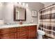 Bathroom featuring granite countertops, dual sinks, a framed mirror and a shower-tub combo at 3241 E Hampton Ln, Gilbert, AZ 85295