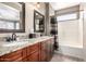 Bathroom featuring granite countertops, dual sinks, and a shower-tub combo with neutral earth tones at 3241 E Hampton Ln, Gilbert, AZ 85295