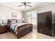 Bedroom featuring a wooden bed frame, wood-look floors, and a large dark wood wardrobe at 3241 E Hampton Ln, Gilbert, AZ 85295