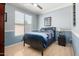 Bedroom with blue walls featuring carpet and a bed with black frame near a window at 3241 E Hampton Ln, Gilbert, AZ 85295