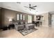 Inviting living room featuring a large sectional sofa, modern ceiling fan, and a seamless transition to the dining area at 3241 E Hampton Ln, Gilbert, AZ 85295