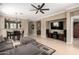 Spacious living room showcases a large TV, modern ceiling fan, and an open layout connecting to the dining area at 3241 E Hampton Ln, Gilbert, AZ 85295