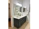 Bathroom with double vanity, modern fixtures, large mirror, and neutral tile floors at 3284 E Sandy Way, Gilbert, AZ 85297
