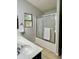 A bathtub in the bathroom with glass doors and a large single basin vanity with natural light at 3284 E Sandy Way, Gilbert, AZ 85297