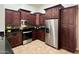 A well-equipped kitchen with stainless steel appliances, dark wood cabinets and granite counter tops and mosaic backsplash at 3284 E Sandy Way, Gilbert, AZ 85297