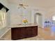 Kitchen island with dark wood cabinets, light granite, and an open concept living space at 3284 E Sandy Way, Gilbert, AZ 85297