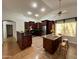 Well-lit kitchen with dark wood cabinets, a kitchen island, and stainless-steel appliances at 3284 E Sandy Way, Gilbert, AZ 85297