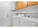 Laundry room with front loading washer and dryer and wooden cabinets above at 3284 E Sandy Way, Gilbert, AZ 85297
