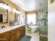 Elegant bathroom with a freestanding tub, a walk-in shower, and a double vanity with wood cabinets at 34942 N Camp Fire Cir, San Tan Valley, AZ 85144