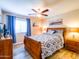 Bedroom with ceiling fan, queen bed, wood furniture, and stylish decor at 34942 N Camp Fire Cir, San Tan Valley, AZ 85144
