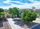 This home features a charming exterior with mature trees and a well-manicured lawn, enhancing its curb appeal at 34942 N Camp Fire Cir, San Tan Valley, AZ 85144