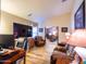 Living room featuring multiple seating areas, wood laminate flooring, and large screen TV at 34942 N Camp Fire Cir, San Tan Valley, AZ 85144