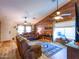 Inviting living room featuring a wooden accent wall, ceiling fan, and comfortable leather furniture at 34942 N Camp Fire Cir, San Tan Valley, AZ 85144