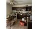 Dated kitchen featuring dark wood cabinetry, tile floors, and cluttered countertops and dining area at 3556 E Helena Dr, Phoenix, AZ 85032