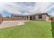 Wide view of a spacious backyard featuring artificial grass, a patio, stepping stones, gravel and block wall at 4150 S Neutron --, Mesa, AZ 85212
