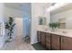 Bathroom featuring dual vanity sinks, a framed mirror, and a walk-in shower with glass door at 4150 S Neutron --, Mesa, AZ 85212