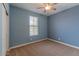 Bedroom with blue accent wall featuring neutral carpet, a ceiling fan, and a window at 4150 S Neutron --, Mesa, AZ 85212