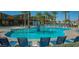 Sparkling community pool featuring lounge chairs, palm trees, and basketball hoop at 4150 S Neutron --, Mesa, AZ 85212