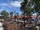 Inviting outdoor patio with picnic tables, red umbrellas, and palm trees for casual dining at 4150 S Neutron --, Mesa, AZ 85212