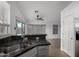 Kitchen sink with granite countertops, stainless fixtures and view to living area at 4321 E Rowel Rd, Phoenix, AZ 85050