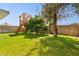 A lush backyard featuring a unique wooden play structure and mature landscaping, ideal for outdoor enjoyment at 440 N New Hvn, Mesa, AZ 85205