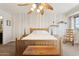 Spacious bedroom featuring a decorative leaf fan, a wooden bed frame, and a neutral color scheme at 440 N New Hvn, Mesa, AZ 85205