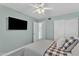 A calming bedroom is completed with a ceiling fan, natural light and a television offering comfort and modern living at 4545 E Wescott Dr, Phoenix, AZ 85050
