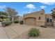 Desert home showcasing a two-car garage and low-maintenance landscape, set against a clear blue sky at 4545 E Wescott Dr, Phoenix, AZ 85050
