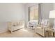 A serene Bedroom featuring a crib, changing table, and comfortable seating, creating a calming environment at 4584 W Detroit St, Chandler, AZ 85226