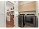 Convenient laundry room with modern washer and dryer units and wooden cabinets at 4584 W Detroit St, Chandler, AZ 85226