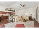 Open-concept living room with a view of the kitchen, featuring a ceiling fan, hardwood floors, and neutral color palette at 4584 W Detroit St, Chandler, AZ 85226